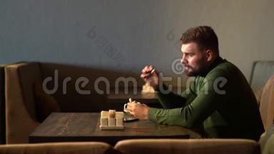 一个时髦男人坐在咖啡馆里，用<strong>蓝牙耳机</strong>听音乐